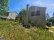 Rear exterior view of a multi-story home with mature trees in the backyard at 6296 Marbut Farms Trl, Lithonia, GA 30058