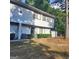 Two-story townhouse featuring a well-maintained front yard with a trimmed hedge and mature trees at 3818 Mulkey Sw Cir, Marietta, GA 30008