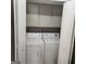 Enclosed laundry area featuring a white washer and dryer with storage shelves above at 3818 Mulkey Sw Cir, Marietta, GA 30008