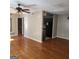 Open living room with vinyl floors transitions to the kitchen with dark appliances and cabinetry at 3818 Mulkey Sw Cir, Marietta, GA 30008
