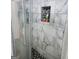 Shower with marble tile surround and black hexagon mosaic tile niche and flooring at 3818 Mulkey Sw Cir, Marietta, GA 30008