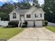 Charming two-story home with attached two-car garage, landscaped yard, and traditional architectural details at 85 Creekside Trl, Covington, GA 30016