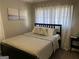 Comfortable bedroom featuring soft natural light from the white patterned curtains, wood floors, and stylish decor at 3385 M L King Jr Sw Dr, Atlanta, GA 30331
