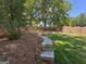 The fenced backyard features a lush lawn, landscape stone, and mature trees at 4080 Longford Ne Dr, Marietta, GA 30066
