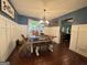 Dining room with dark hardwood floors, wainscoting, and modern chandelier lighting at 4080 Longford Ne Dr, Marietta, GA 30066