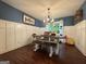 Dining room with dark hardwood floors, wainscoting, and modern chandelier lighting at 4080 Longford Ne Dr, Marietta, GA 30066