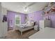 Charming bedroom with purple walls, white furniture, and decorative shelving, with an exterior window at 1120 Twin Bridge Ln, Peachtree City, GA 30269