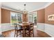 Bright dining area featuring a wooden table, modern light fixture, and large window at 1120 Twin Bridge Ln, Peachtree City, GA 30269