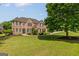 Traditional brick home with manicured lawn and landscape, complemented by dark shutters and detailed entrance at 1120 Twin Bridge Ln, Peachtree City, GA 30269