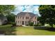 Traditional brick home with manicured lawn and landscape, complemented by dark shutters and detailed entrance at 1120 Twin Bridge Ln, Peachtree City, GA 30269