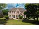 Traditional brick home with manicured lawn and landscape, complemented by dark shutters and detailed entrance at 1120 Twin Bridge Ln, Peachtree City, GA 30269