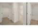 Well-lit hallway showcases access to a bathroom and bedroom, complemented by neutral carpet and tile flooring at 620 Whitman Ln # 31, Stockbridge, GA 30281