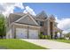 Charming brick and siding home with a two-car garage and a concrete driveway, perfect for Gathering living at 150 Gadson Dr, Fayetteville, GA 30214