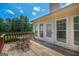Back deck features wooden surface, metal table and four chairs, and view of backyard at 3533 Saddlebrook Dr, Loganville, GA 30052