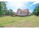 Exterior back of home features a wooden deck and spacious green yard at 3533 Saddlebrook Dr, Loganville, GA 30052