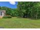 Large, grassy backyard offers a serene setting with mature trees and easy access to the home at 3533 Saddlebrook Dr, Loganville, GA 30052