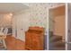 Finished basement area with floral wallpaper, staircase and built in wooden storage unit at 3533 Saddlebrook Dr, Loganville, GA 30052