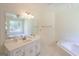 Bright bathroom featuring a large mirror, soaking tub, and modern vanity at 3533 Saddlebrook Dr, Loganville, GA 30052