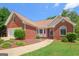 Well-maintained brick home with lush landscaping, a sidewalk, and a welcoming front entrance at 3533 Saddlebrook Dr, Loganville, GA 30052