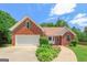 Charming brick home featuring an attached garage, manicured landscaping, and a curved walkway leading to the entrance at 3533 Saddlebrook Dr, Loganville, GA 30052