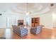 Open living room with tray ceiling, fireplace, hardwood floors, and a view of the backyard at 3533 Saddlebrook Dr, Loganville, GA 30052