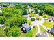 Overhead view of a home with a lawn, landscaping, a deck, an outdoor dining table, a pool, and surrounding neighborhood at 137 River Birch Dr, Carrollton, GA 30116