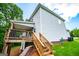 Side view of a home featuring a wooden deck and staircase leading to a landscaped backyard at 137 River Birch Dr, Carrollton, GA 30116
