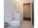 Well-lit bathroom showcasing a white vanity with a mirror and a toilet with tiled floor at 137 River Birch Dr, Carrollton, GA 30116