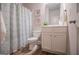 Full bathroom with patterned shower curtain, wood flooring, and a white sink vanity at 137 River Birch Dr, Carrollton, GA 30116