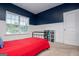 Inviting bedroom with dark blue accent wall, white wainscoting, and a window with natural light at 137 River Birch Dr, Carrollton, GA 30116