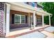 Charming front porch with brick accents, white columns, and decorative flower pots, creating a welcoming entrance at 137 River Birch Dr, Carrollton, GA 30116