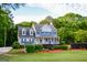 Charming two-story traditional home with blue shutters, a welcoming front porch, and professionally landscaped yard at 855 Hood Rd, Fayetteville, GA 30214