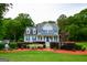 Charming two-story home with blue shutters, lush greenery, and a manicured lawn at 855 Hood Rd, Fayetteville, GA 30214