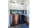 Laundry room featuring stainless steel washer and dryer with blue backsplash tiles and storage cabinets at 855 Hood Rd, Fayetteville, GA 30214
