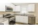 Modern kitchen with stainless steel appliances, granite counters and sleek white cabinetry at 338 Mount Zion Rd, Hapeville, GA 30354