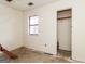 A bedroom is in a state of disrepair, with a visible window and bare walls, as well as an open closet at 8005 Big Rock Dr, Douglasville, GA 30134