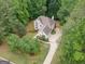 Aerial view of a home with lush, mature trees, a long driveway, and well-maintained landscaping at 215 Barrington Grange Dr, Sharpsburg, GA 30277