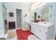 Bathroom with double vanity sinks and a shower with glass doors and neutral-colored walls at 215 Barrington Grange Dr, Sharpsburg, GA 30277