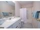 Neutral-colored bathroom with a single sink vanity and a bathtub with a shower curtain at 215 Barrington Grange Dr, Sharpsburg, GA 30277