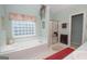 Bright bathroom featuring a large soaking tub with a window and a glass-enclosed shower at 215 Barrington Grange Dr, Sharpsburg, GA 30277