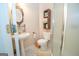 Cozy bathroom featuring a pedestal sink, decorative mirror, toilet, and walk-in shower with a glass door at 215 Barrington Grange Dr, Sharpsburg, GA 30277