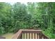 A wooden deck with a view of lush greenery and mature trees creating a private and serene outdoor space at 215 Barrington Grange Dr, Sharpsburg, GA 30277