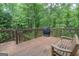Spacious wooden deck features a grill and wooden bench, perfect for entertaining in a serene outdoor setting at 215 Barrington Grange Dr, Sharpsburg, GA 30277