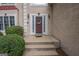 Close-up of front door with wreath, surrounded by manicured bushes and stucco walls at 215 Barrington Grange Dr, Sharpsburg, GA 30277