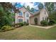 Stucco home with manicured lawn and landscaping and a front entry with an arched window at 215 Barrington Grange Dr, Sharpsburg, GA 30277