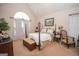 Bright main bedroom features a four-poster bed, large arched window and sitting area at 215 Barrington Grange Dr, Sharpsburg, GA 30277