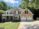 Charming two-story brick home featuring a manicured lawn and a two-car garage at 4710 Kinsmon Pl, Marietta, GA 30062