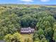 Secluded home nestled amongst lush green trees on a partially wooded lot under a blue sky at 95 Fern Ct, Stockbridge, GA 30281