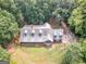 Aerial view of a home nestled amongst lush greenery and trees with a large lot size at 95 Fern Ct, Stockbridge, GA 30281