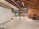 Unfinished basement with exposed ceiling, concrete floor, brick accent wall and wood burning stove at 95 Fern Ct, Stockbridge, GA 30281